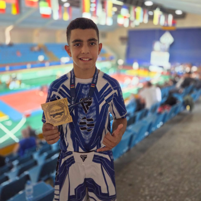 Mark Ghambaryan holding his gold medal after victory at the Jiu-Jitsu Armenian Open Championship, proud of his achievement