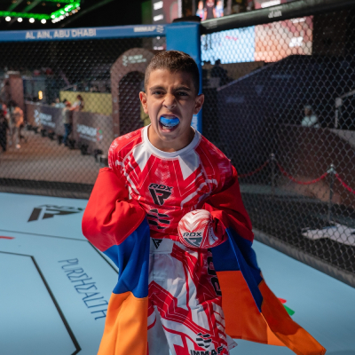 Mark Ghambaryan standing on the cage and screaming in celebration after winning at the IMMAF World Championship 2025