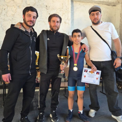 Mark Ghambaryan posing with his coaches Artur Zakaryan, Gor Grigoryan, and Artur Grigoryan.
